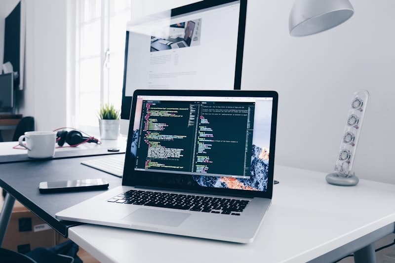Developer coding on a laptop with an external monitor